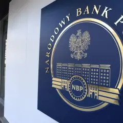Złote godło i napis "NARODOWY BANK POLSKI" na granatowej tablicy, symbolizujące stabilność finansową kraju.
