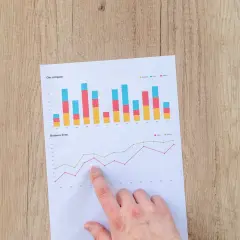 Analiza wykresów finansowych, w tym danych dotyczących obligacji indeksowanych inflacją, na drewnianym tle.
