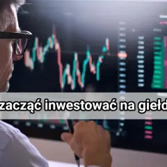 Mężczyzna w okularach analizuje wykresy na monitorze, ucząc się, jak działa giełda papierów wartościowych.