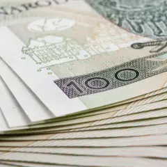 Stos banknotów 100 zł, symbolizujący inwestycję w obligacje skarbowe marzec 2026.