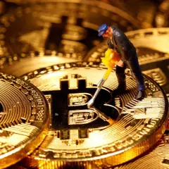 Figurka górnika z kilofem na złotych monetach Bitcoin. Cena kryptowaluty zależy od wielu czynników, w tym od popytu i podaży.