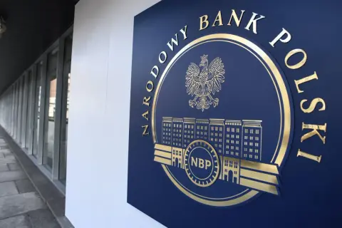 Złote godło i napis "NARODOWY BANK POLSKI" na granatowej tablicy, symbolizujące stabilność finansową kraju.