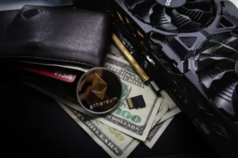 Portfel, karta Visa, moneta Ethereum, banknoty 100 USD i karta graficzna. To wszystko może być związane z tym, co to jest airdrop kryptowaluty.