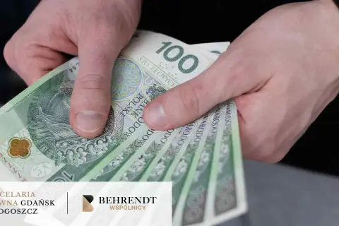 Dłoń trzyma banknoty 100 zł. Jak odzyskać pieniądze z obligacji Getin Bank? Prawnicy pomogą.