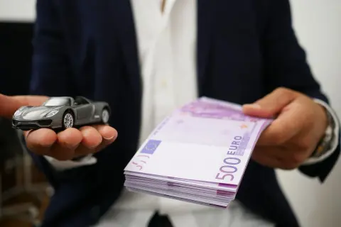 Model samochodu i stos banknotów 500 euro symbolizują cesję leasingu.