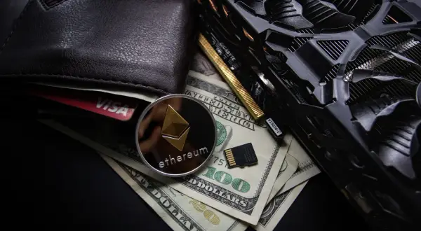 Portfel, karta Visa, moneta Ethereum, banknoty 100 USD i karta graficzna. To wszystko może być związane z tym, co to jest airdrop kryptowaluty.