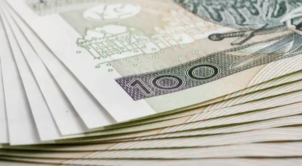 Stos banknotów 100 zł, symbolizujący inwestycję w obligacje skarbowe marzec 2026.