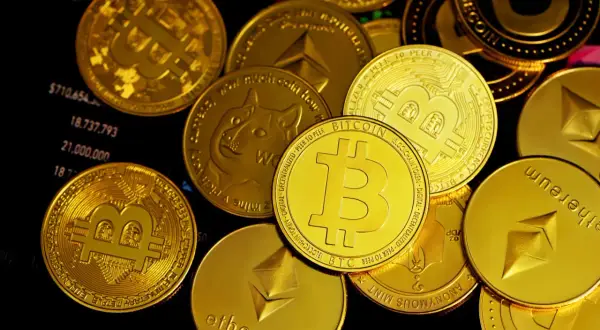 Złote monety z symbolami Bitcoin, Ethereum i Dogecoin leżą na wykresie finansowym. To pokazuje, co to są kryptowaluty.