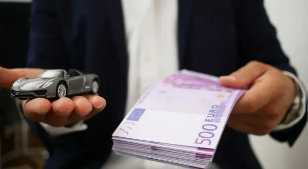 Model samochodu i stos banknotów 500 euro symbolizują cesję leasingu.