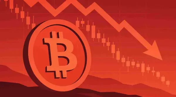 Symbol bitcoina na tle wykresu świecowego z czerwoną strzałką w dół. To wizualizacja tego, dlaczego kryptowaluty spadają.