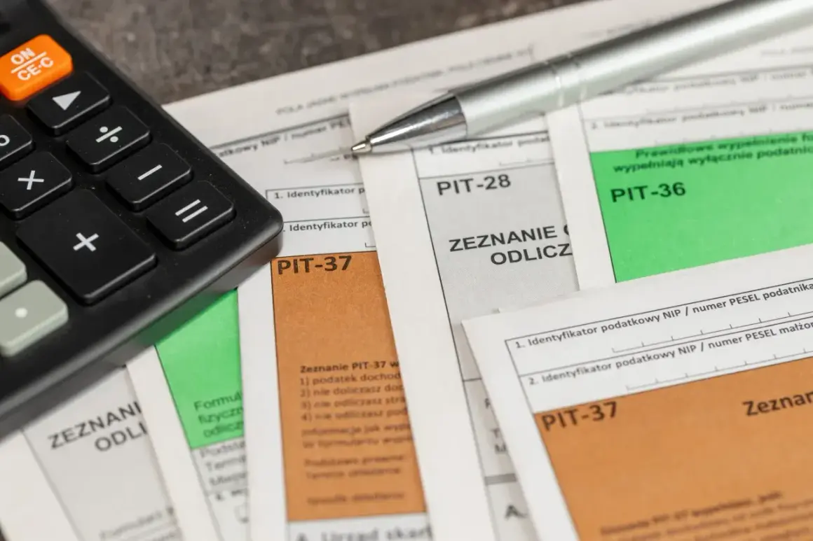 Kalkulator i długopis na dokumentach PIT-28, PIT-36, PIT-37. Czas na rozliczenie roczne, w tym pit-28 ryczałt.