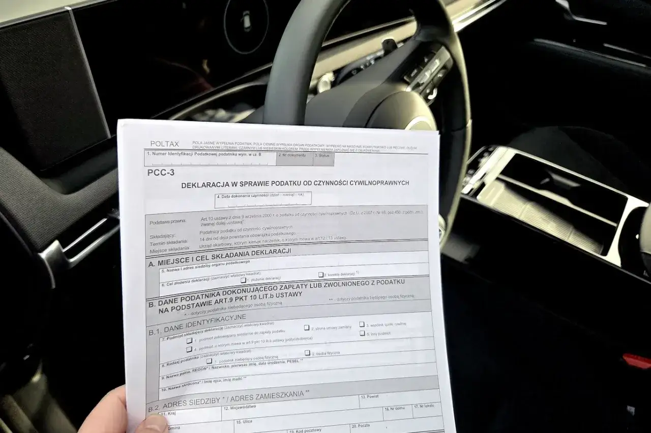Deklaracja PCC-3 w sprawie podatku od czynności cywilnoprawnych, leżąca na kierownicy samochodu.
