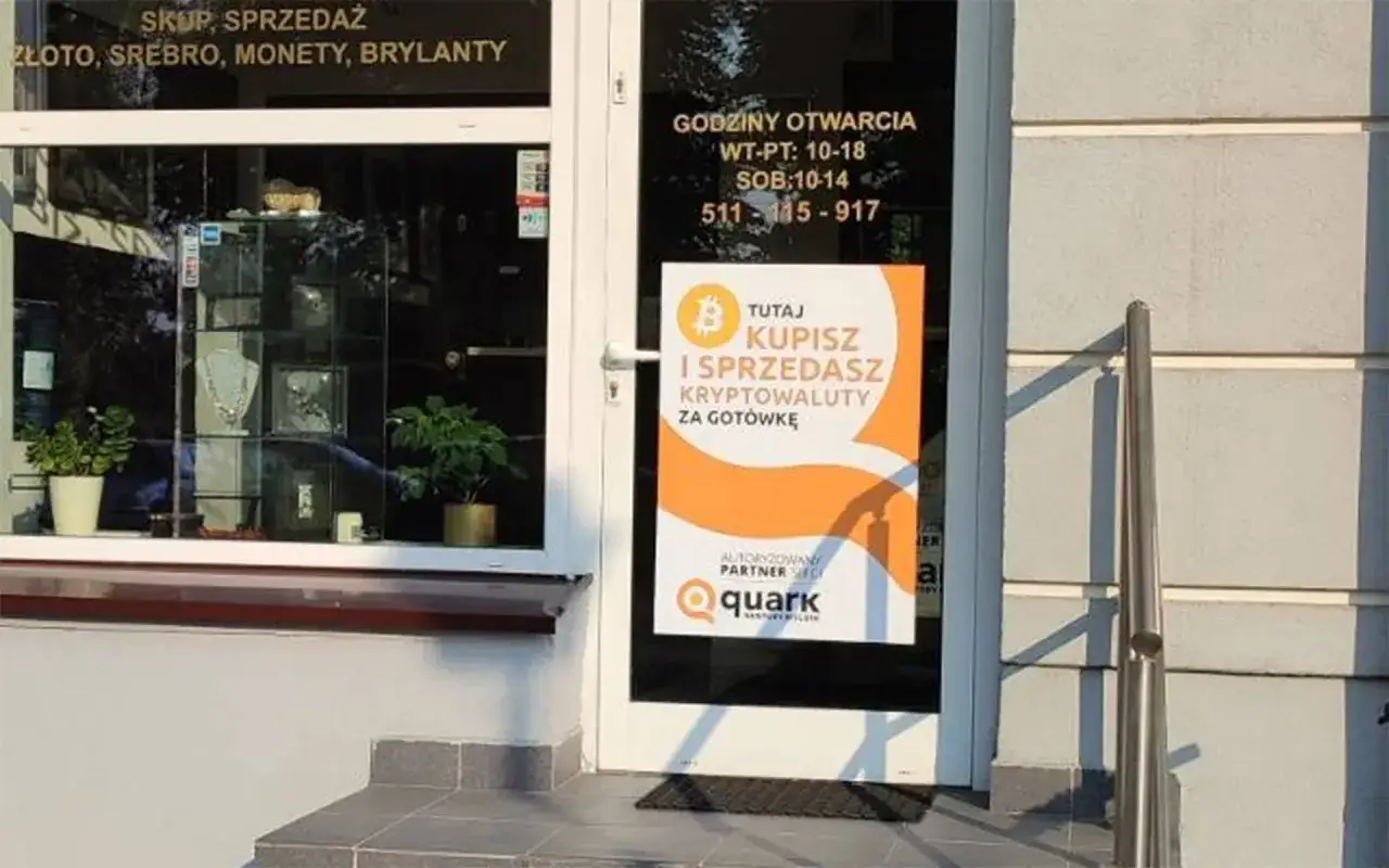 Na drzwiach sklepu widnieje pomarańczowy plakat informujący: 