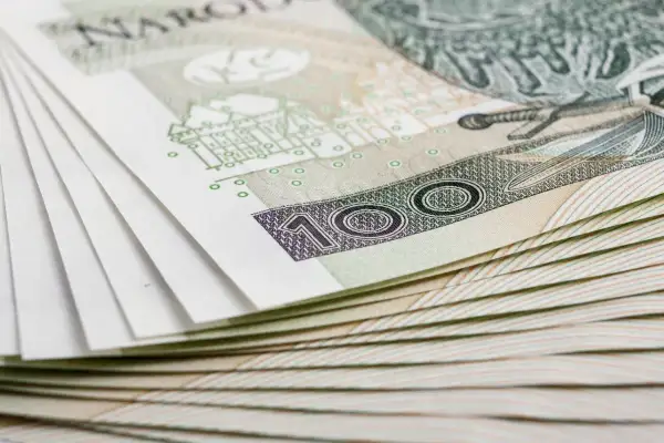 Stos banknotów 100 zł, symbolizujący inwestycję w obligacje skarbowe marzec 2026.