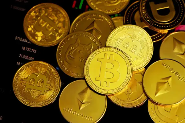 Złote monety z symbolami Bitcoin, Ethereum i Dogecoin leżą na wykresie finansowym. To pokazuje, co to są kryptowaluty.